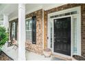 Front porch with rocking chairs and black front door at 1142 Preserve Park Dr, Loganville, GA 30052