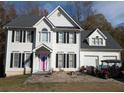 Two-story house with white siding, black shutters, and a pink door at 405 Baneberry Bnd, Peachtree City, GA 30269