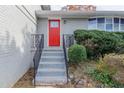 Close-up of the red front door with black wrought iron railings and gray brick exterior at 1151 Martin Rd, Stone Mountain, GA 30088