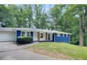 Charming blue home with white trim, a covered porch, and a landscaped yard at 495 Valley Ne Ln, Atlanta, GA 30328