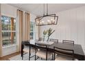 Elegant dining room featuring a dark wood table, modern chandelier, and large windows at 6101 Marigold Way, Atlanta, GA 30349