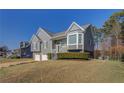 Gray two-story home with white trim, a two-car garage, and front yard landscaping at 1103 Etowah Valley Ln, Woodstock, GA 30189