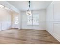 Formal dining room with wainscoting, hardwood floors, and chandelier at 4045 Hosch Retreat Drive, Buford, GA 30519