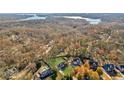 Aerial view showcasing a neighborhood with houses and lake views at 5705 Windjammer Pt, Cumming, GA 30041