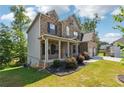 Brick and siding two-story house with front porch and landscaping at 180 Wentworth Ln, Villa Rica, GA 30180