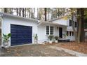 Inviting white house with a navy blue garage door, driveway, and landscaping at 4001 Red Oak Dr, Atlanta, GA 30340