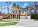 Inviting brick home featuring a welcoming front porch, three-car garage, and landscaped yard at 4093 Longleaf Ln, Tucker, GA 30084