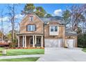 Charming two-story brick home with a covered entry, three-car garage, and lush lawn at 4093 Longleaf Ln, Tucker, GA 30084