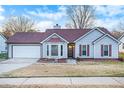 One-story home featuring a red roof, attached garage, and well-maintained lawn at 320 Spring Creek Dr, Stockbridge, GA 30281