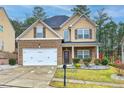 Two-story single-Gathering home with a brick and beige siding exterior, attached garage, and manicured lawn at 1587 Balvaird Dr, Lawrenceville, GA 30045