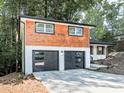 Renovated home with wood and white brick exterior, two-car garage, and green door at 1564 Bubbling Creek Rd, Brookhaven, GA 30319