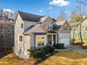 View of a two-story house with a garage and some trees at 264 Creek View Pl, Canton, GA 30114