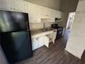 Kitchen with white cabinets, black appliances, and wood-look floor at 4262 Catalpa Park, Ellenwood, GA 30294