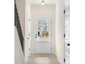 Bright foyer with light wood-look flooring, white walls, and a front door with window panes at 730 Shetland Trl, Cartersville, GA 30121