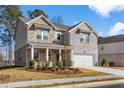 Beautiful new construction home with a stone and brick exterior and a front porch at 1495 Auburn Glen Rd, Dacula, GA 30019