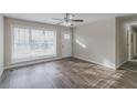 Bright living room with large windows, wood-look flooring, and a ceiling fan at 1347 Peggy Nw Ln, Conyers, GA 30012