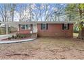 Side view of a brick ranch home nestled among trees at 944 Liberty Hill Ne Rd, Marietta, GA 30066