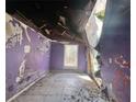 Damaged bedroom with purple walls, tile floor, and exposed ceiling at 202 Hayes St, Villa Rica, GA 30180
