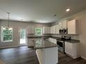 Modern kitchen featuring white cabinetry, stainless steel appliances, and an island with granite countertops at 85 Heyman Dr, Covington, GA 30016