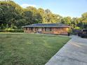 Brick ranch home with solar panels, a concrete driveway, and a large green lawn at 1393 Bolton Nw Rd, Atlanta, GA 30331