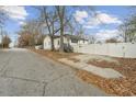Paved driveway and white fence with autumn leaves scattered around at 6214 Hagin St, Douglasville, GA 30134