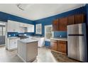 Kitchen with blue walls, white and brown cabinets, and an island at 6214 Hagin St, Douglasville, GA 30134