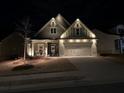 Inviting home exterior illuminated at night, showcasing the front porch and landscaping at 595 Everton Pl, Grayson, GA 30017