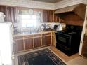 Dated kitchen with wood cabinets, black appliances, and linoleum floor at 2061 Highview Sw Rd, Atlanta, GA 30311