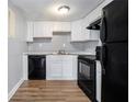 Renovated kitchen with white shaker cabinets, black appliances, and wood-look flooring at 1151 Rankin St # 20A, Stone Mountain, GA 30083