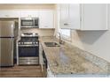 Updated kitchen with stainless steel appliances, white cabinets, and granite countertops at 453 Utoy Sw Cir, Atlanta, GA 30331