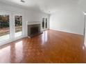 Spacious living area with a brick fireplace, parquet flooring, and French doors at 4727 Garden Hills Dr, Stone Mountain, GA 30083