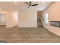 Open living area with wood-look flooring, ceiling fan, and staircase at 1628 Fuma Leaf Way, Mcdonough, GA 30253