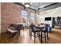 Spacious living area featuring a piano, dining table, exposed brick, and hardwood floors at 1459 Village Park Ct, Atlanta, GA 30319