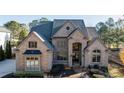 Large brick home with arched entry and professional landscaping at 3229 Carmichael Pl, Duluth, GA 30097