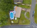 An aerial close-up of the pool and back deck area, including fencing and mature trees at 2818 Kensington Way, Rex, GA 30273