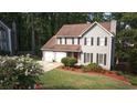 Two-story home with a two-car garage, red front door, and beautiful landscaping at 5166 Ridge Tarn, Acworth, GA 30102