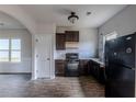 Modern kitchen with dark cabinets, granite countertops, and black appliances at 5537 Union Pointe Pl, Union City, GA 30291