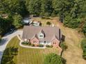 An aerial view showcasing the home's location on a large, wooded lot with a driveway and backyard pool at 151 Dixon Cir, Fayetteville, GA 30215