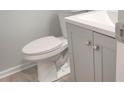 Small bathroom with gray vanity, white toilet, and vinyl flooring at 1909 Granville Dr, Lawrenceville, GA 30043