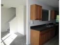 Kitchen with wood cabinets, dark countertops, and view of staircase at 2800 Vining Ridge Ter, Decatur, GA 30034