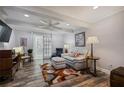 Living room with wood-look tile floors, white walls, ceiling fan, and access to the sunroom at 138 Elysian Nw Way, Atlanta, GA 30327