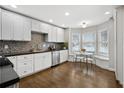 Modern eat-in kitchen, white cabinets, and dark hardwood floors at 2540 Holcomb Springs Dr, Alpharetta, GA 30022