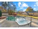 Relaxing backyard oasis featuring a sparkling pool, a hot tub and a pergola at 141 Lost Forest Dr, Mcdonough, GA 30252