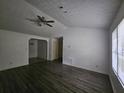 Spacious living room with dark wood-like floors and a ceiling fan at 8095 Flamingo Dr, Jonesboro, GA 30238