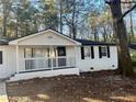 White home with black shutters, covered front porch, and landscaped yard at 1543 California Ave, Conley, GA 30288