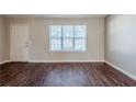 Living room with dark brown wood-look floors and a large window at 1275 To Lani Farm Rd, Stone Mountain, GA 30083