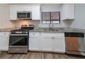Modern kitchen boasts stainless steel appliances, white shaker cabinets, granite countertops, and ample counter space at 5136 Huxley Rd, Stone Mountain, GA 30088