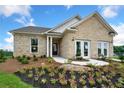 Front yard of charming new construction home with brick exterior and flower bed at 443 Village Ln, Fairburn, GA 30213