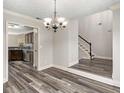 Dining room with a modern chandelier and wood-look flooring, adjacent to the kitchen at 297 Ellesmere Ct, Buford, GA 30518