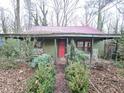 Front porch of green cottage, red door, rocking chairs at 1541 Harbin Sw Rd, Atlanta, GA 30311